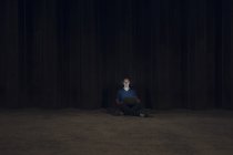 Взрослый мужчина сидит скрестив ноги на земле, используя ноутбук ночью — стоковое фото