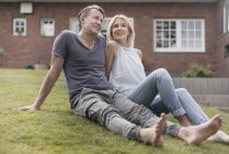 Sorridente coppia matura seduta in giardino di casa — Foto stock