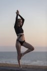 Giovane donna bionda che fa yoga in spiaggia la sera, posizione dell'albero — Foto stock