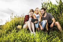 Friends sharing tablet at a cornfield — Stock Photo