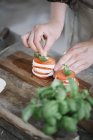 Frauenhände bereiten Caprese-Salat zu — Stockfoto