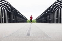 Man running on a bridge — Stock Photo