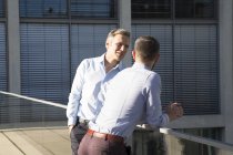 Двоє впевнених бізнесменів говорять на мосту — стокове фото