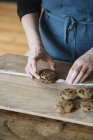 Mains de femme empilant des biscuits végétaliens faits maison au pois chiche, vue partielle — Photo de stock