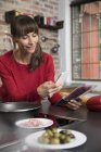 Mujer en productos de escaneo de cocina con su teléfono inteligente — Stock Photo