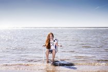Pays-Bas, Zandvoort, fille heureuse assise sur une chaise dans la mer — Photo de stock