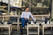 Empresário sentado no café, sorrindo — Fotografia de Stock