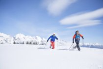 Austria, Tyrol, snowshoe hikers running through snow — Stock Photo