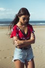 Portrait of fashionable teenage girl standing on sandy beach — Stock Photo