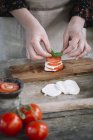 Las manos de la mujer preparando Ensalada Caprese - foto de stock