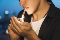 Молодий чоловік курить суглоб на розмитому тлі — стокове фото