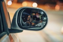 Reflexão do homem do espaço no espelho da asa do carro à noite — Fotografia de Stock