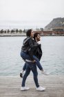 España, Barcelona, pareja joven y feliz divirtiéndose en el paseo marítimo - foto de stock