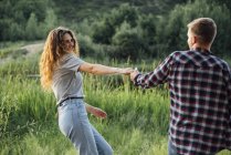 Romantic couple having fun in nature holding hands — Stock Photo