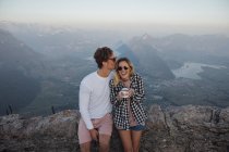 Switzerland, Grosser Mythen, happy young couple on a hiking trip having a break at sunrise — Stock Photo