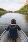 Mujer sentada en barco en el lago en la naturaleza - foto de stock