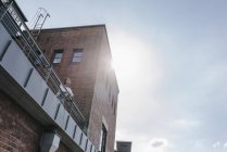 Бизнесмен, стоящая на террасе промышленного здания — стоковое фото
