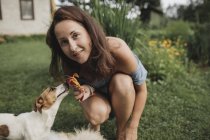 Portrait de femme souriante avec Jack Russel Terrier dans le jardin — Photo de stock