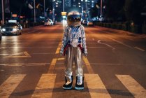 Raumfahrer steht nachts auf der Straße in der Stadt — Stockfoto