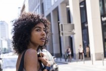 Porträt einer jungen Frau mit lockigem Haar in der Stadt — Stockfoto
