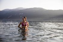 Souriante jeune femme dans un lac — Photo de stock