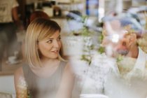 Junge Frau sieht Mann in einem Café an — Stockfoto