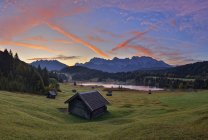 Germania, Baviera, Werdenfelser Land, lago Geroldsee con fienile al tramonto, sullo sfondo le montagne del Karwendel all'alba — Foto stock