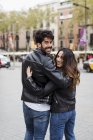 Spain, Barcelona, young couple embracing and walking in city — Stock Photo