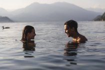Jovem casal feliz em um lago sorrindo um para o outro — Fotografia de Stock