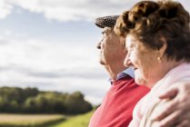 Primo piano di coppia anziana che si abbraccia in campo soleggiato — Foto stock