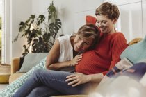 Heureux lesbiennes couple sentiment mouvements de bébé ventre de l 'enceinte mère — Photo de stock