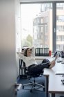 Businesswoman relaxing in office with feet on desk — Stock Photo