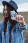 Young woman showing instant photo of herself, close-up — Stock Photo