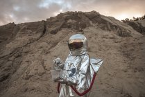 Spaceman on nameless planet taking sample of sand — Stock Photo