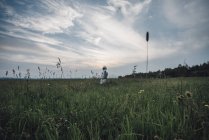 Homme de l'espace explorant la nature, debout dans une prairie fleurie — Photo de stock