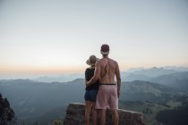 Switzerland, Grosser Mythen, young couple on a hiking trip at sunrise looking at view — Stock Photo
