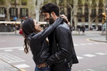 Happy young couple hugging on street — Stock Photo