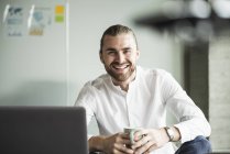 Portrait of smiling young businessman in office — Stock Photo