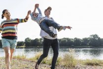 Happy family walking at riverside on sunny summer day — Stock Photo