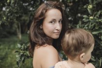 Porträt einer Mutter mit Baby im Garten — Stockfoto