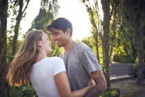 Glückliches junges Paar umarmt und küsst sich im Sommer in einem Park — Stockfoto