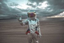 Spaceman pointing at something on nameless planet — Stock Photo