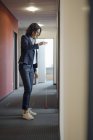 Mature businesswoman standing in office corridor and playing with yoyo — Stock Photo