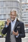 Retrato de risa maduro hombre de negocios hablando en el teléfono móvil - foto de stock