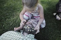 Bambina che decora la barba del padre con margherite sul prato in giardino — Foto stock