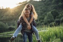 Romantic couple spending time in nature, embracing at sunset — Stock Photo