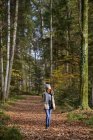 Рыжая девушка-подросток наслаждается осенним лесом — стоковое фото