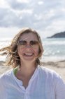 Ritratto di donna felice in occhiali da sole sulla spiaggia — Foto stock