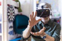 Retrato de hombre maduro en casa usando gafas de realidad virtual - foto de stock