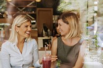 Due giovani donne felici in un caffè — Foto stock
